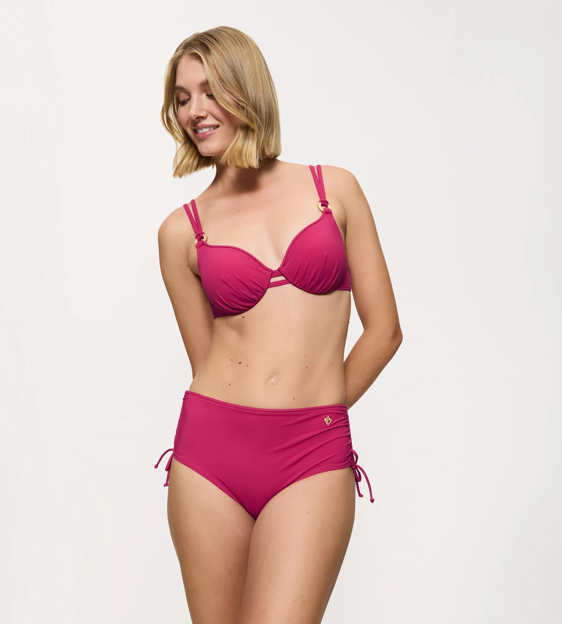 Model wearing the Summer Twist bikini, featuring a high-coverage brief and adjustable sides, in vibrant pink color.