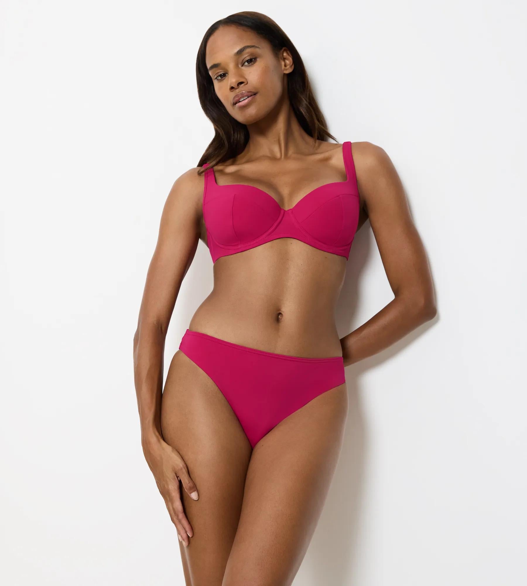 Summer Twist bikini top in bright pink on a model, showcasing adjustable straps and padded bust support.