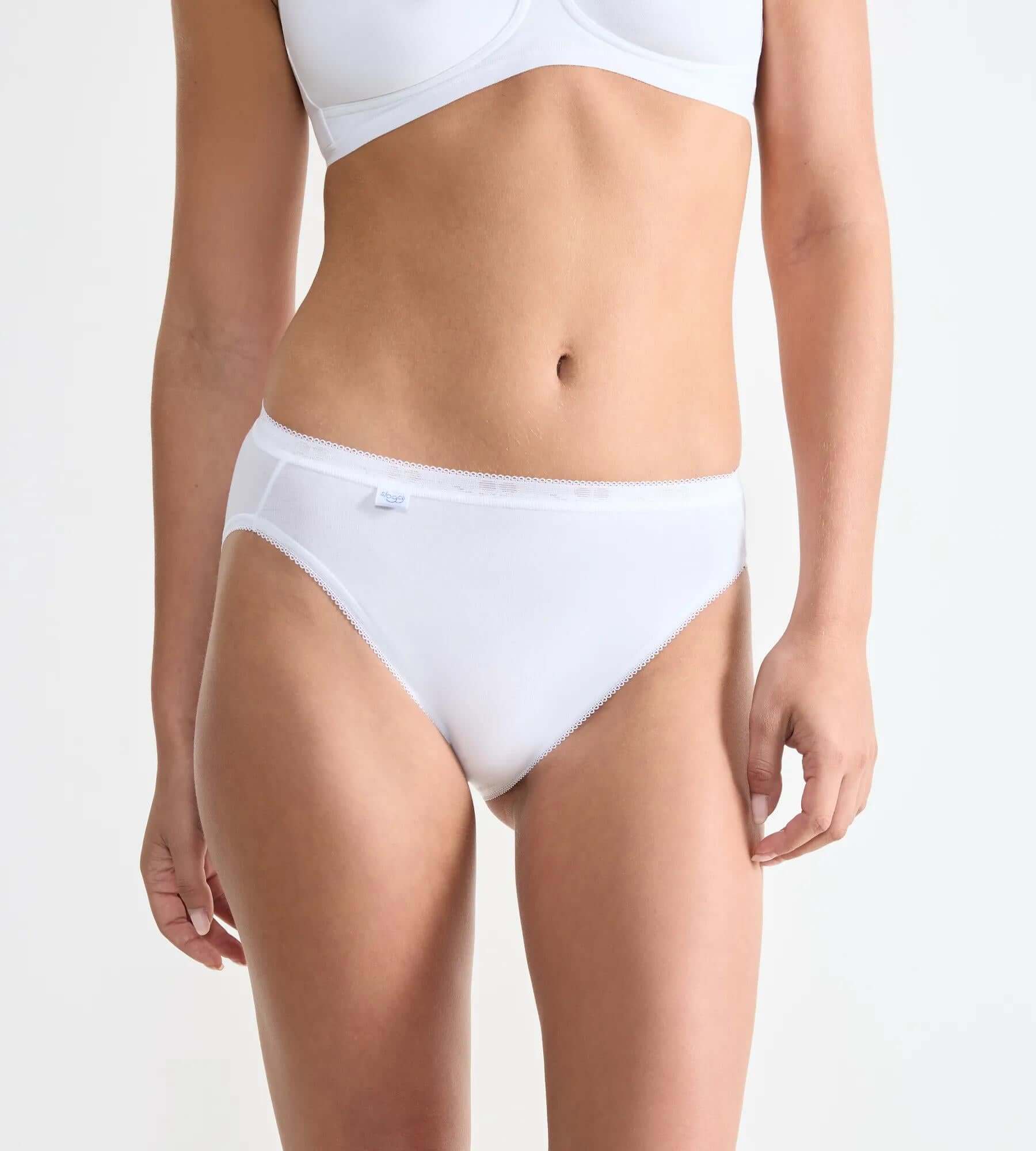 sloggi Basic+ 3-pack featuring a woman wearing white Tai Briefs from the Basic+ series, showcasing soft cotton and comfort.