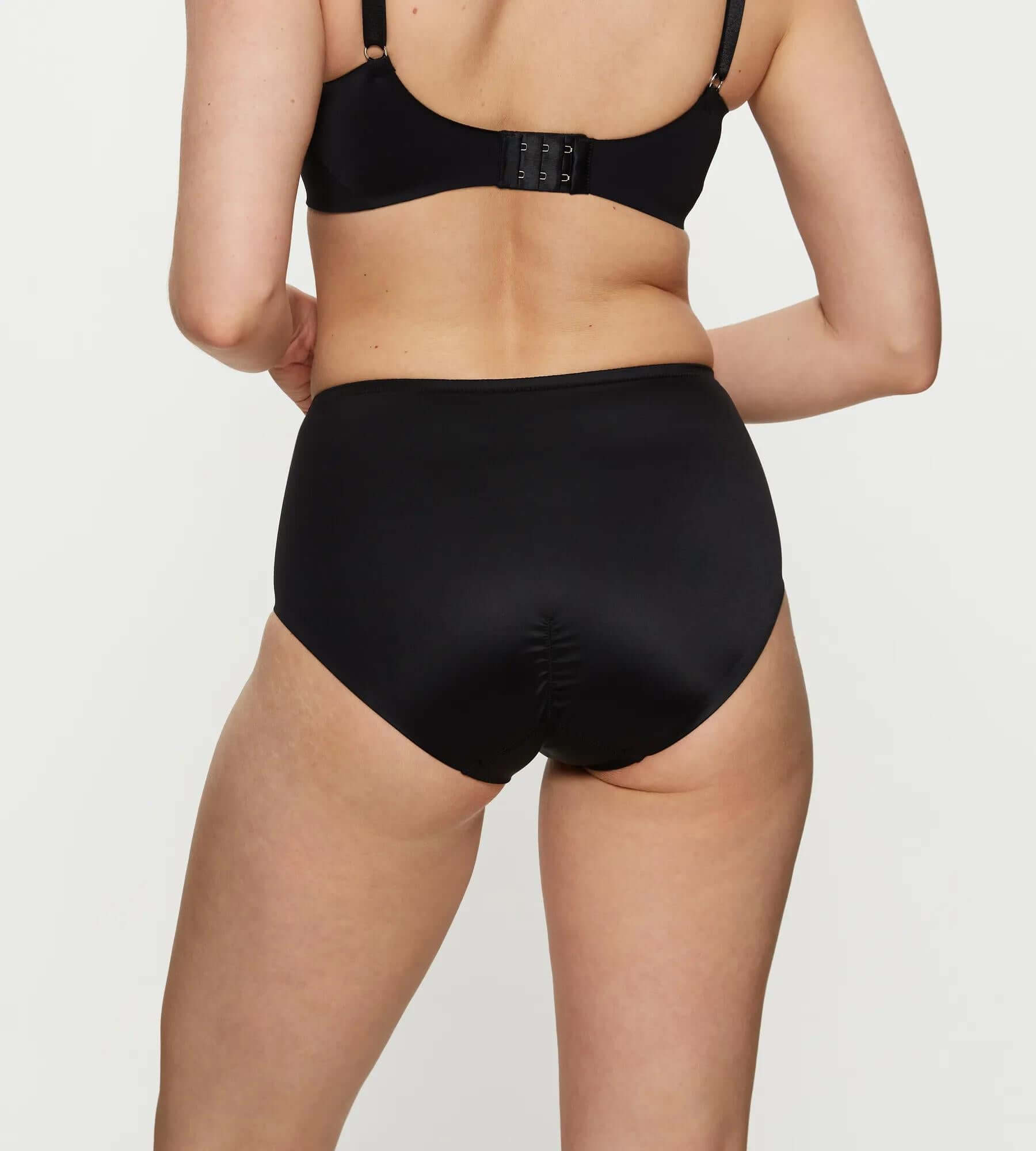 Back view of woman wearing True Shape Sensation high waist maxi brief, showcasing seamless leg opening and defined silhouette.