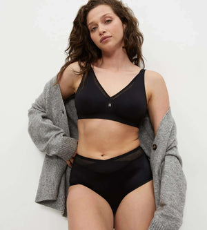 Model wearing True Shape Sensation underwear set with a black v-neck bra and high-waisted briefs.