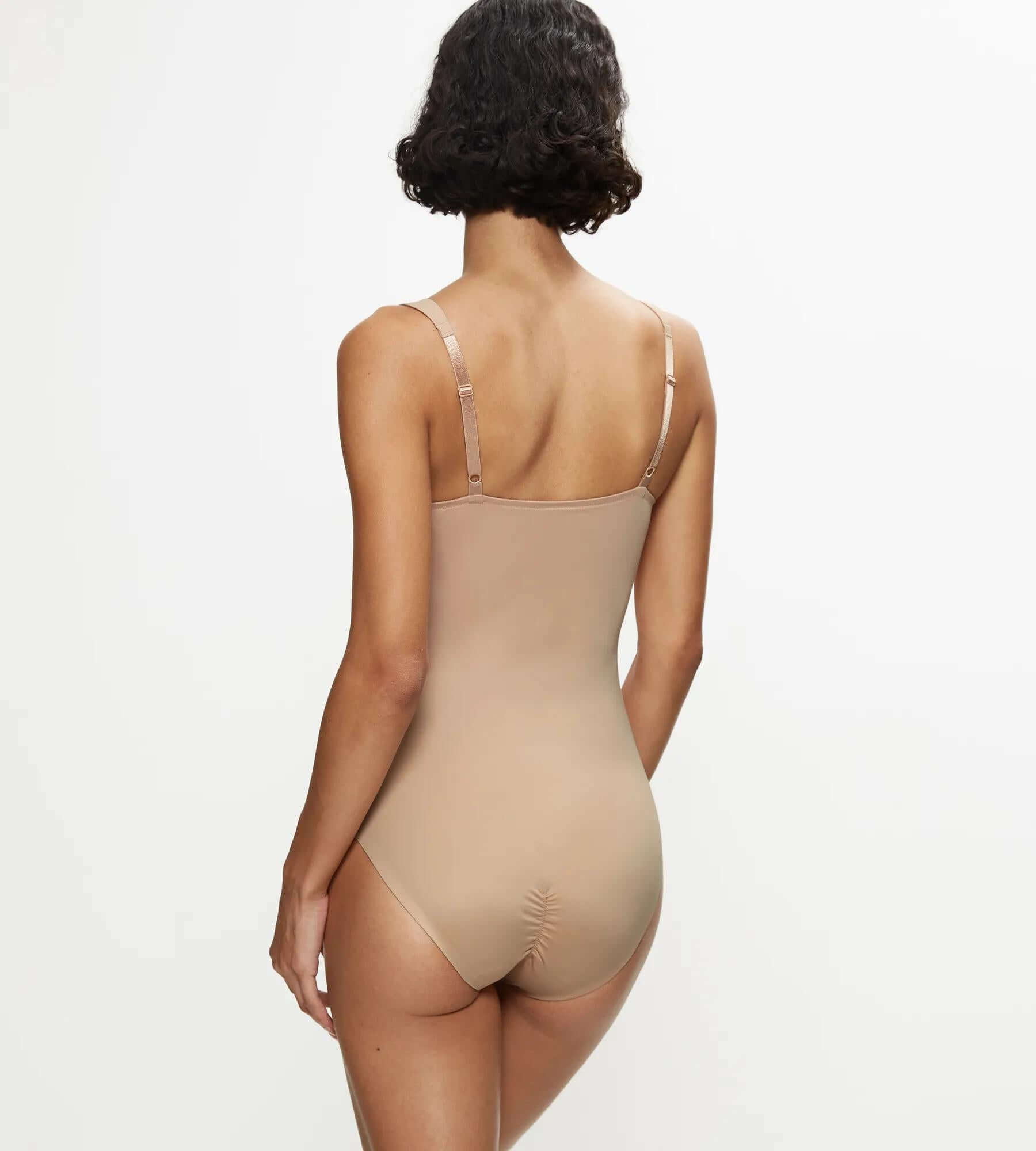 Model showcasing the back of the True Shape Sensation bodysuit in a soft nude color, designed for a flawless bodycon fit.