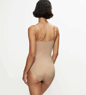 Model showcasing the back of the True Shape Sensation bodysuit in a soft nude color, designed for a flawless bodycon fit.