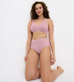 True Shape Sensation T: Model wearing pink high-waisted underwear and matching bra, showcasing a smooth silhouette.