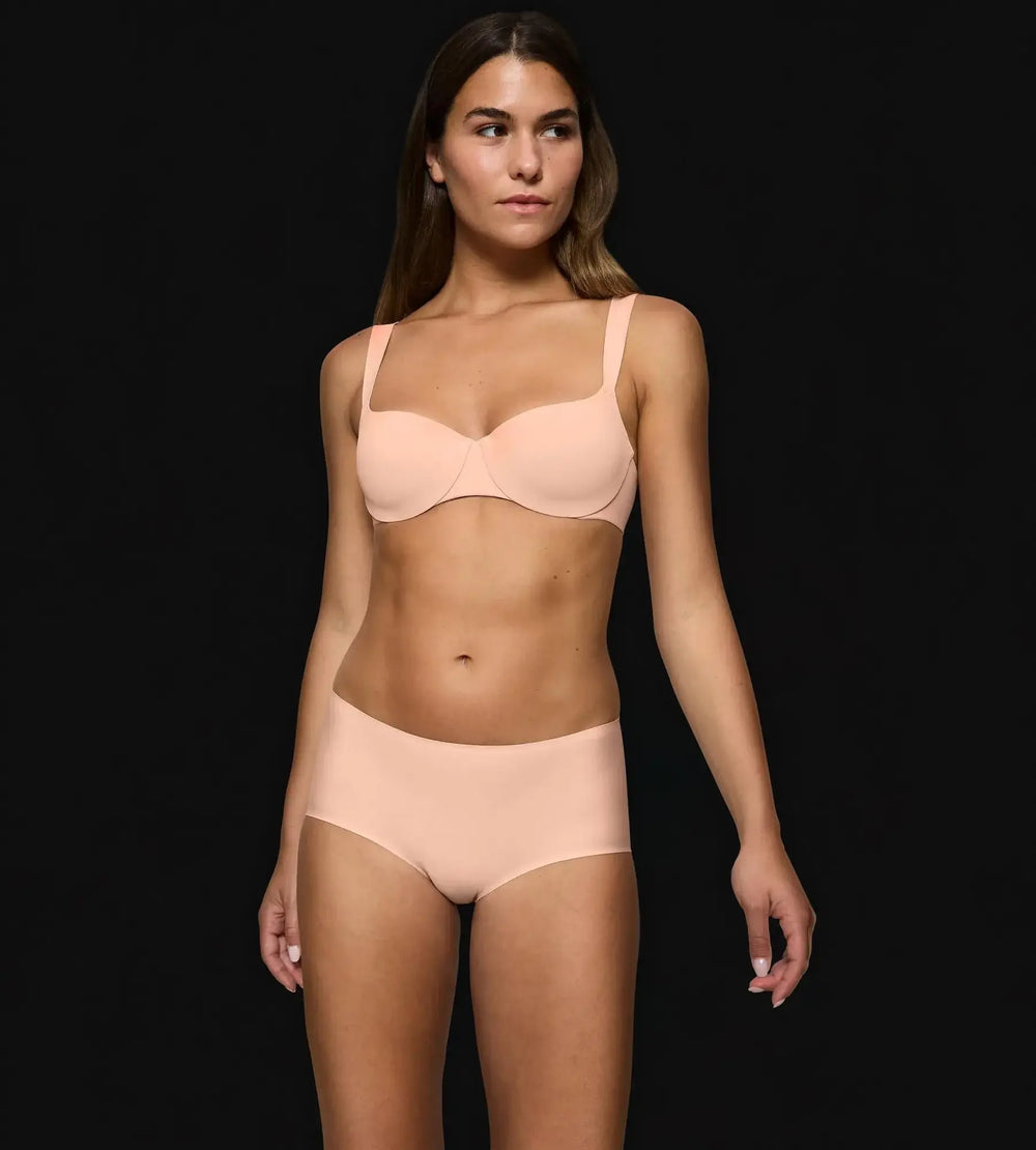 Model wearing Body Make-Up Illusion lingerie set in soft cream color, showcasing smooth, fitted design for a seamless look.