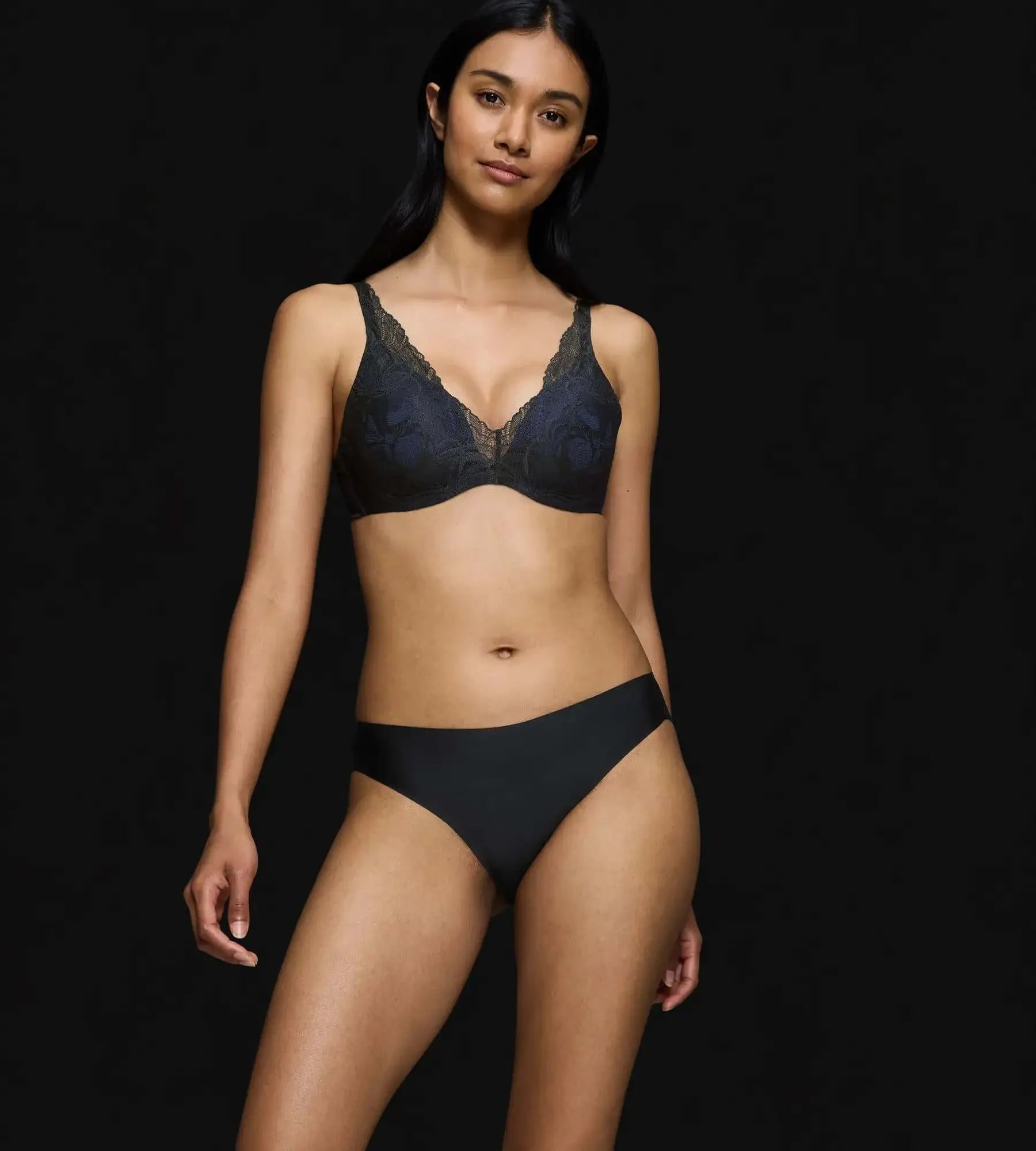 Model wearing Body Make-Up Illusion Lace bra with seamless fit, showcasing comfort and style in a black backdrop.
