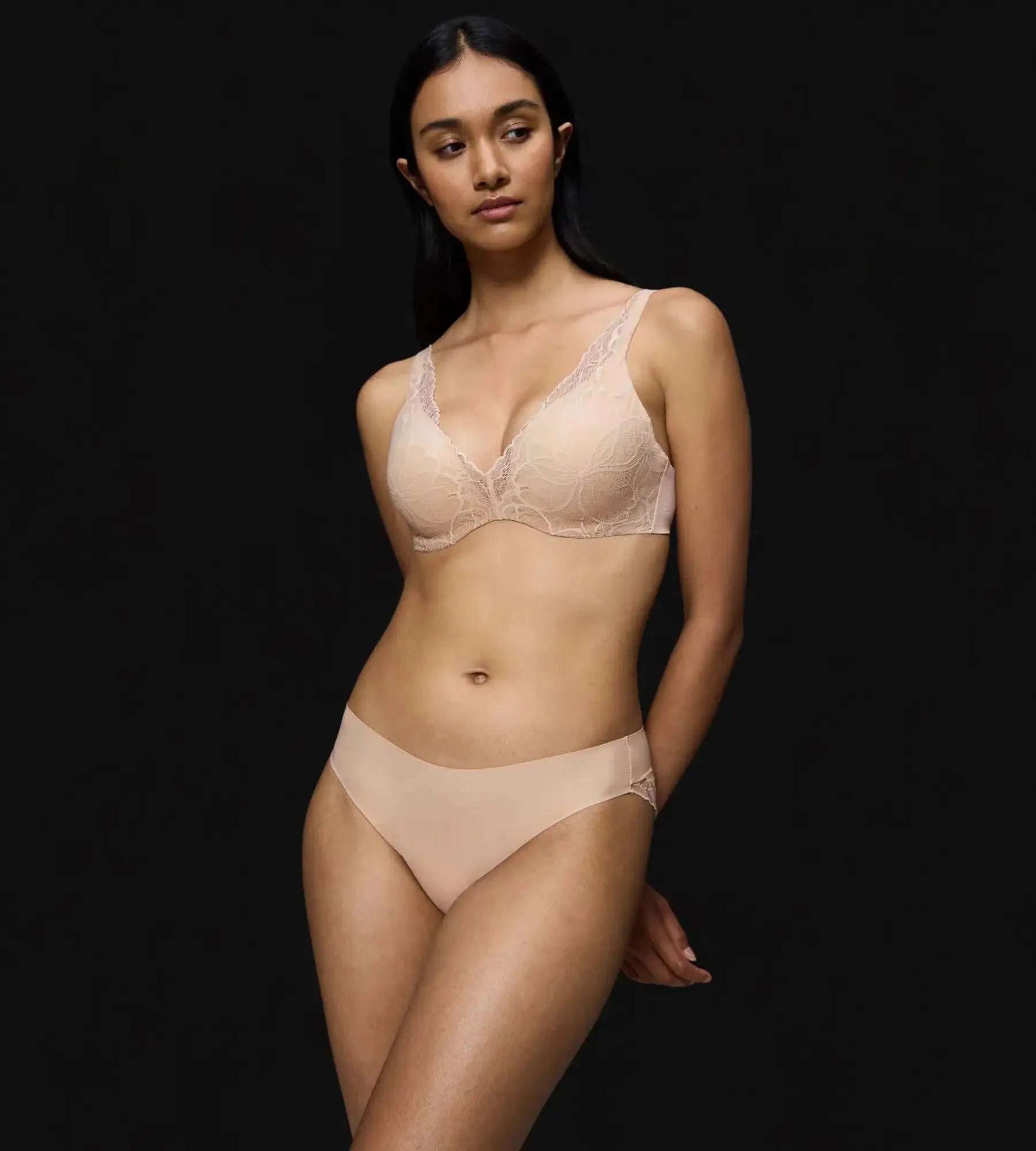 Model wearing Body Make-Up Illusion Lace bra and matching brief on a black background.