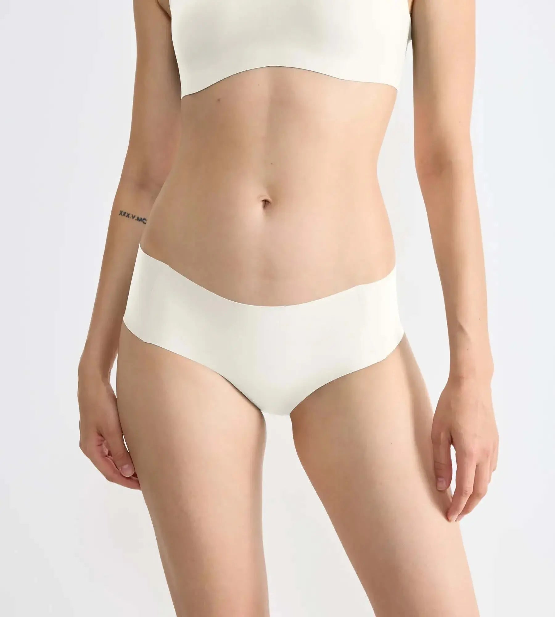 Model wearing sloggi ZERO Feel seamless hipster briefs in cream color, showcasing the super-soft and comfortable design.